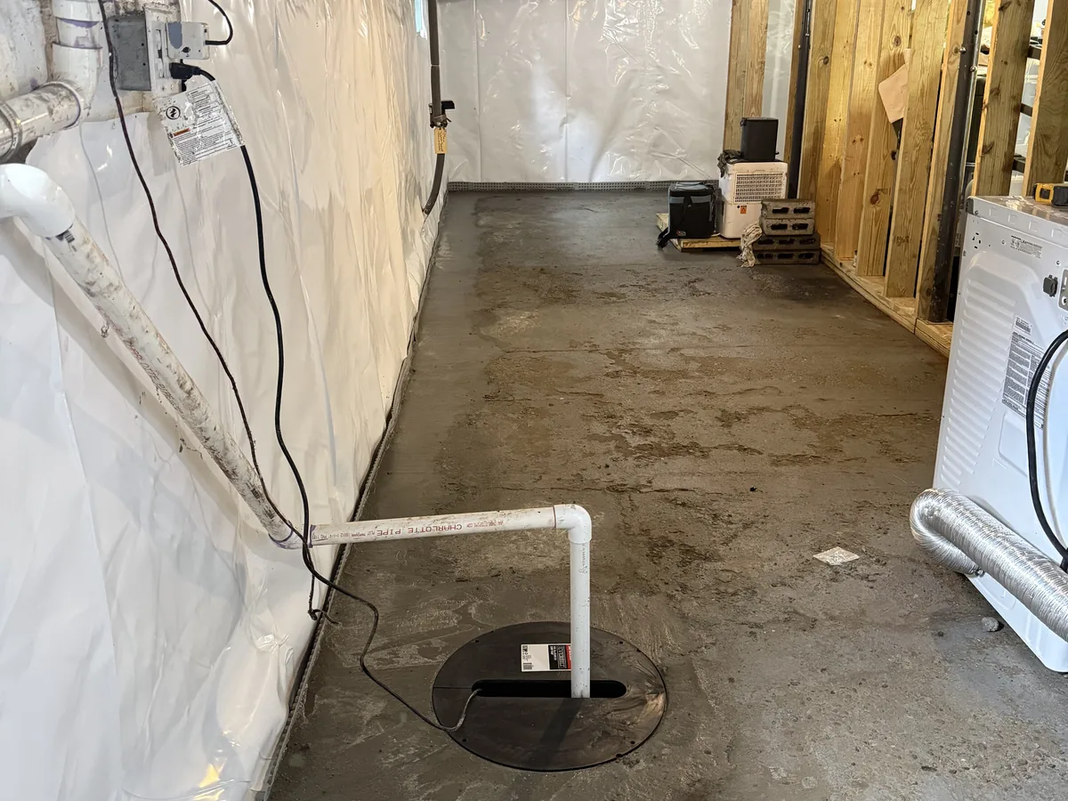 The same basement finished: concrete restored over the trench and the sump lid sealed