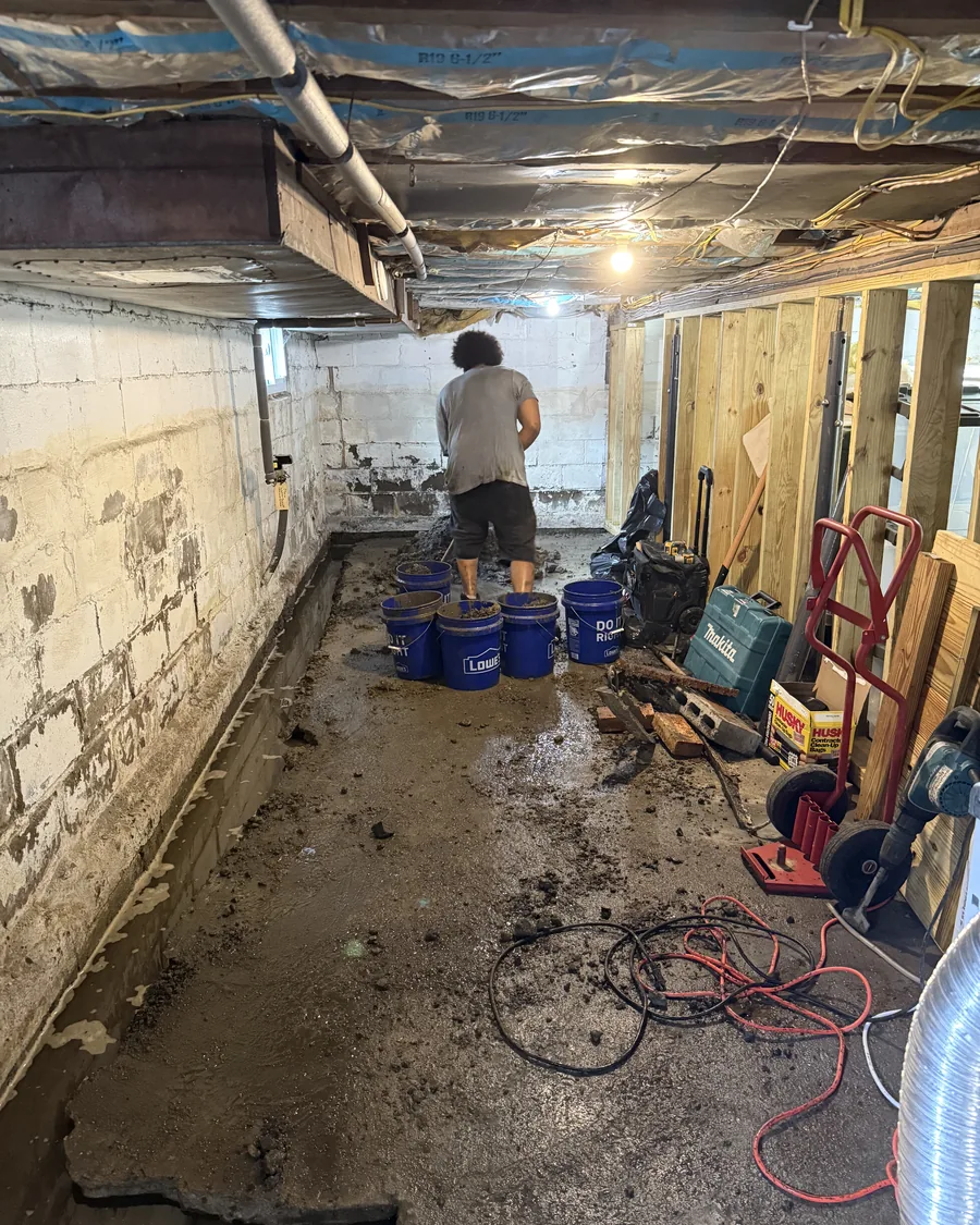 Infinity Dry Basement crew member excavating the perimeter trench during an interior drainage installation